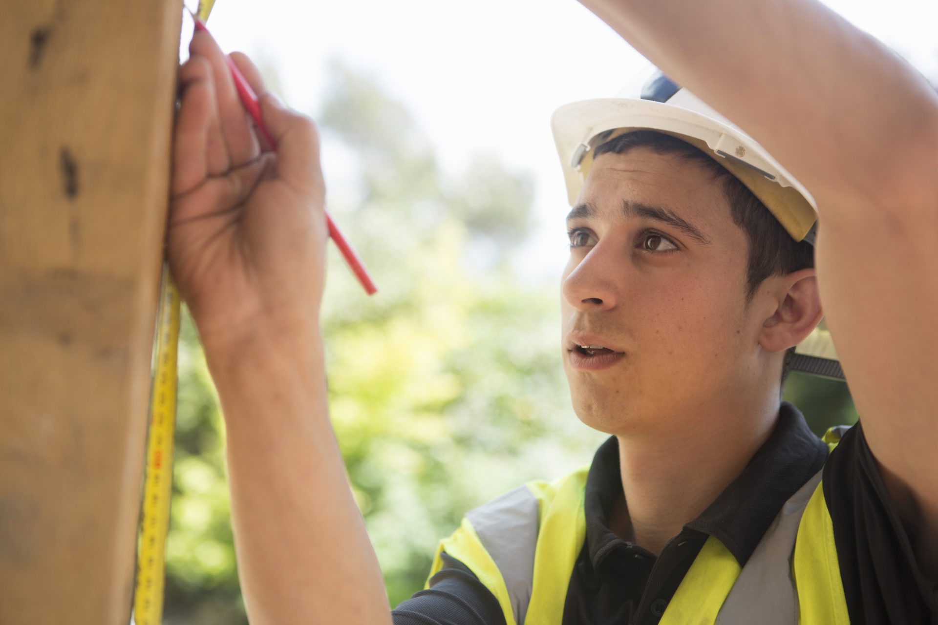 Construction worker wearing high visibility vest and safety helmet.